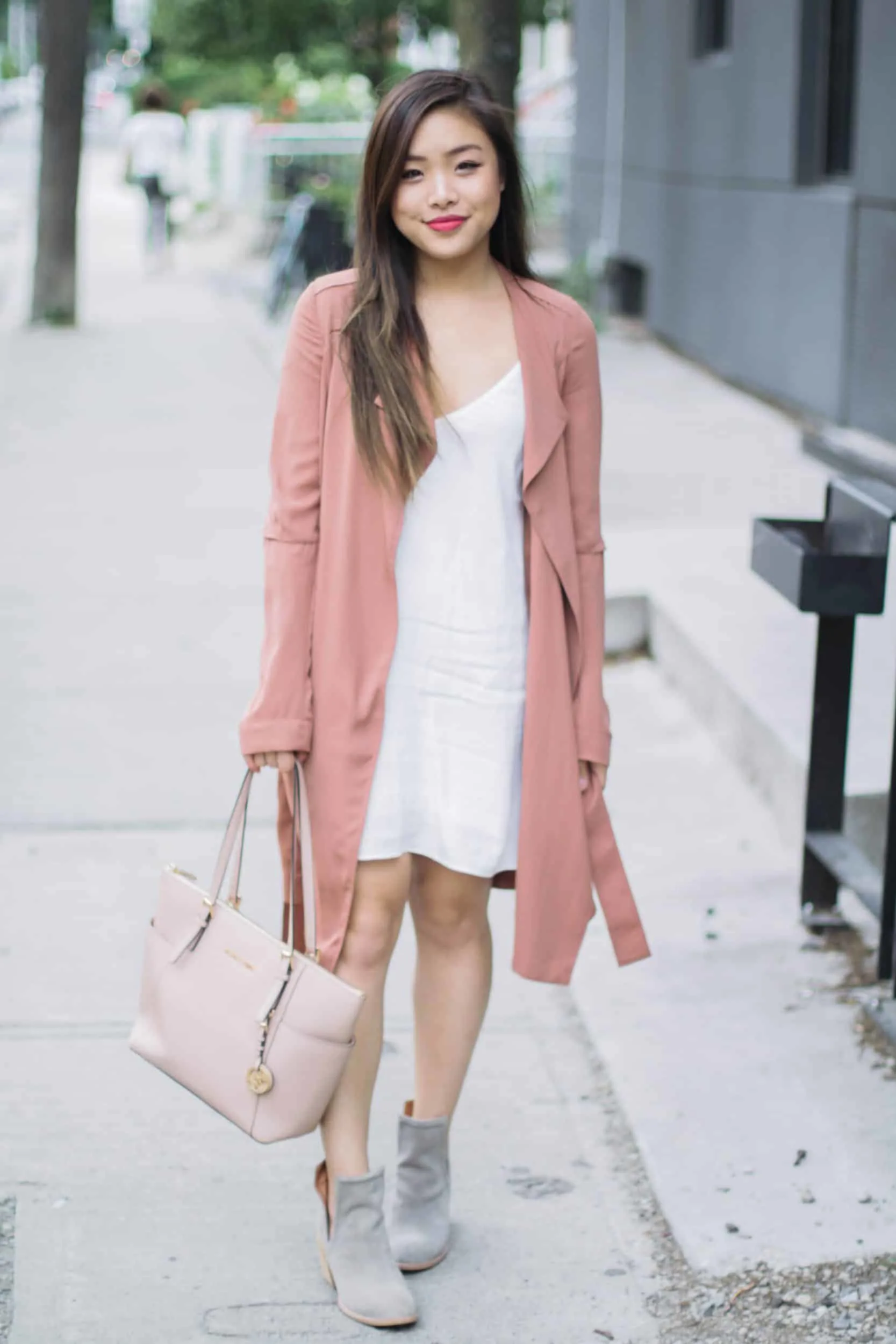Summer outfit featuring Aritzia white slip dress, pink trench coat, Jeffrey Campbell grey suede booties, and nude Michael Kors bag