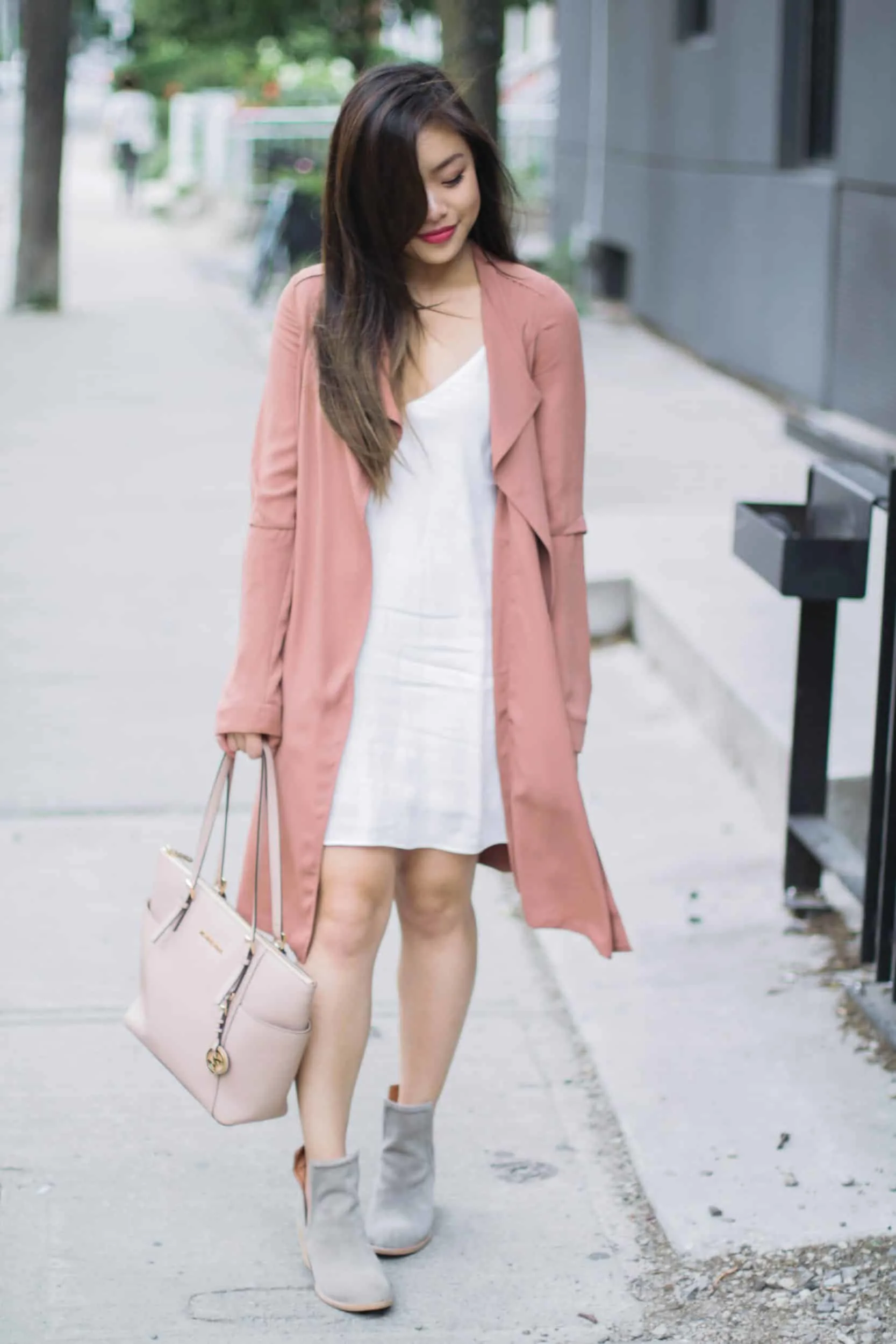 Summer outfit featuring Aritzia white slip dress, pink trench coat, Jeffrey Campbell grey suede booties, and nude Michael Kors bag