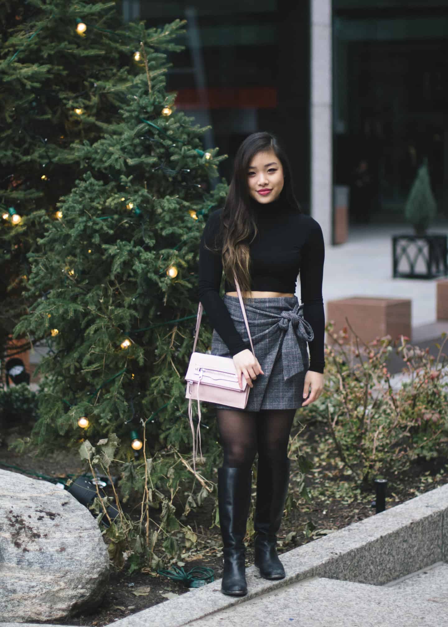 Holiday outfit idea featuring black turtleneck, plaid skirt, and tall leather boots