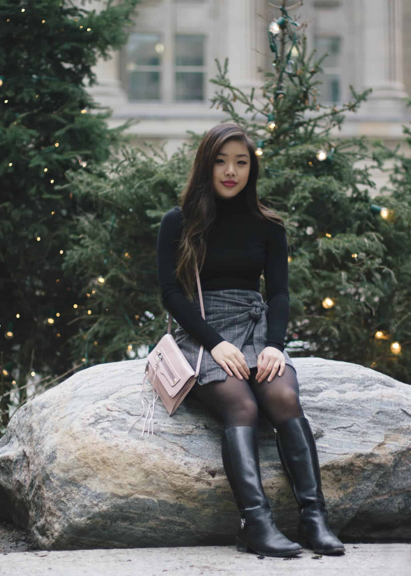 Holiday outfit idea featuring black turtleneck, plaid skirt, and tall leather boots