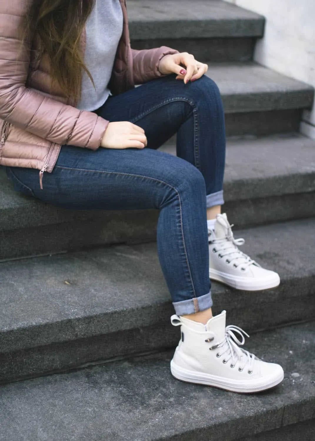 Winter outfit idea featuring Aritzia pink puffer jacket, cropped grey hoodie, Guess denim, and Converse Winter Boots