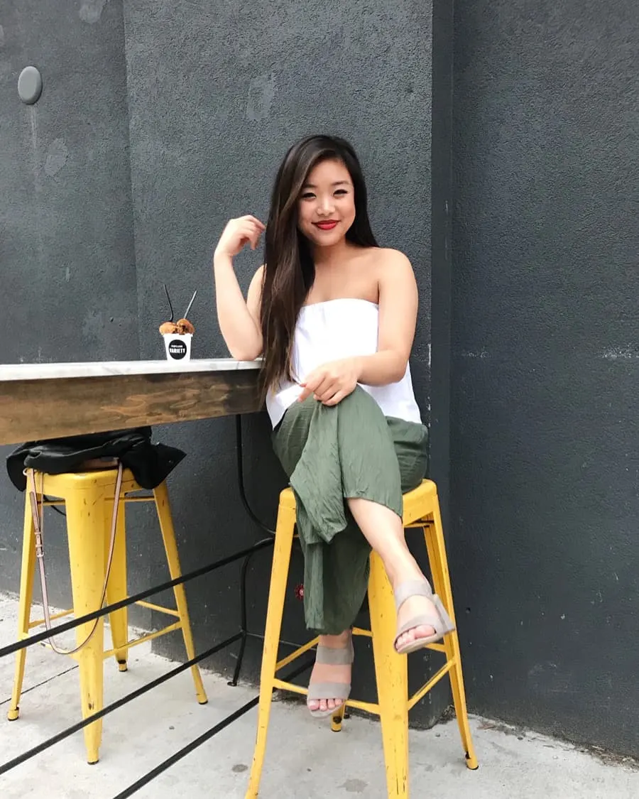 Summer outfit featuring a white strapless top, military green pants, and grey strappy sandals