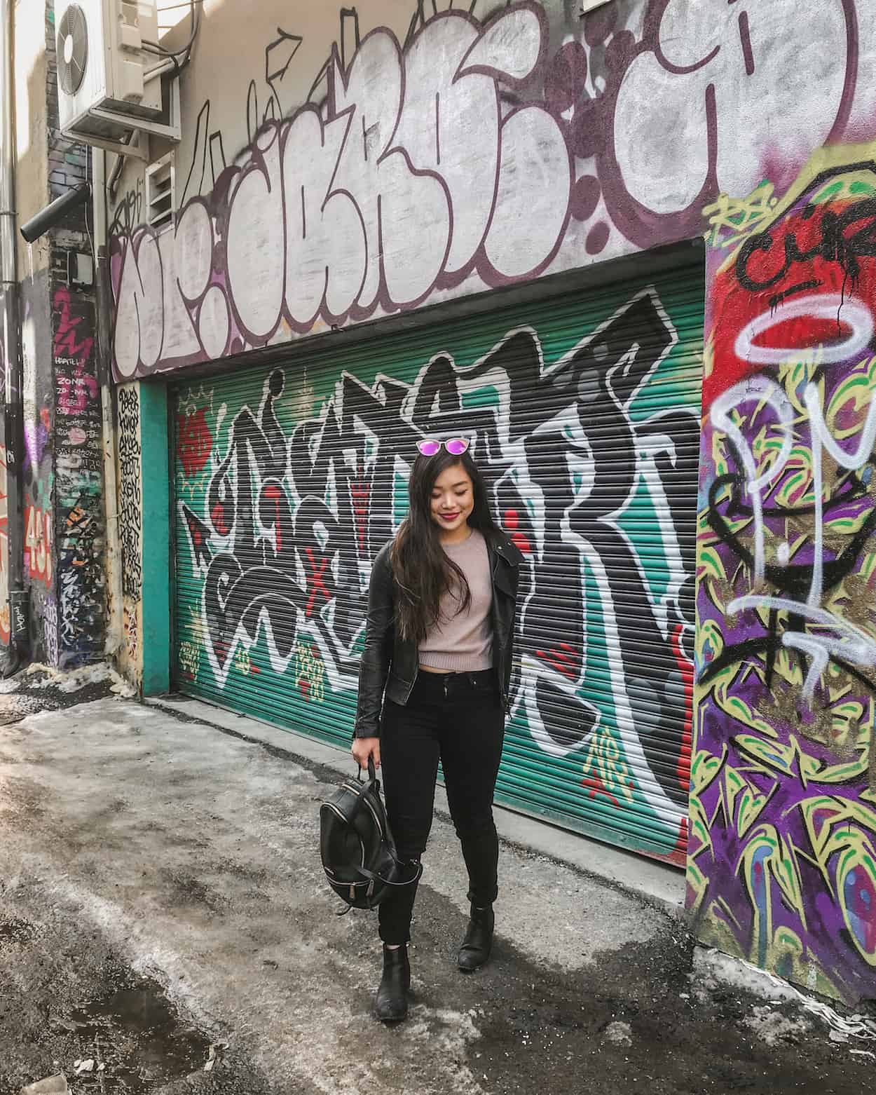 An outfit of the day in front of a graffiti wall in Toronto