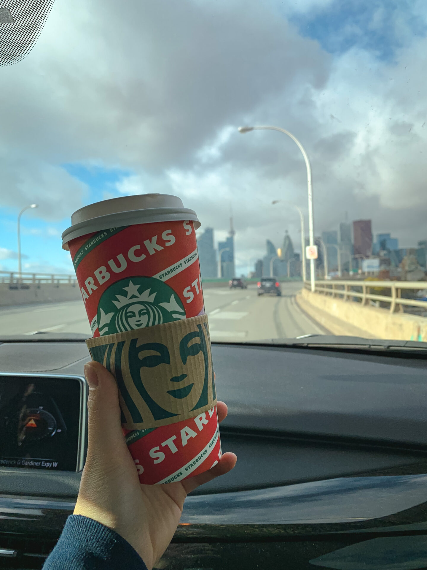 Holding Starbucks holiday drink on the Toronto Gardiner Express highway