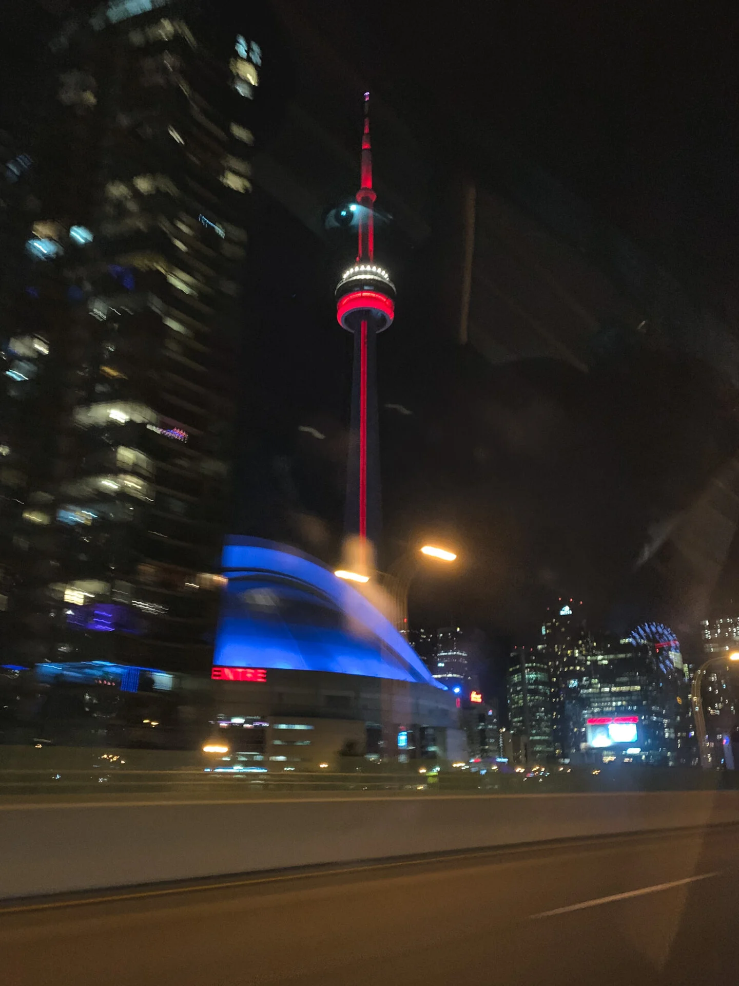 Driving by the CN Tower on the Gardiner Express highway in Toronto at night