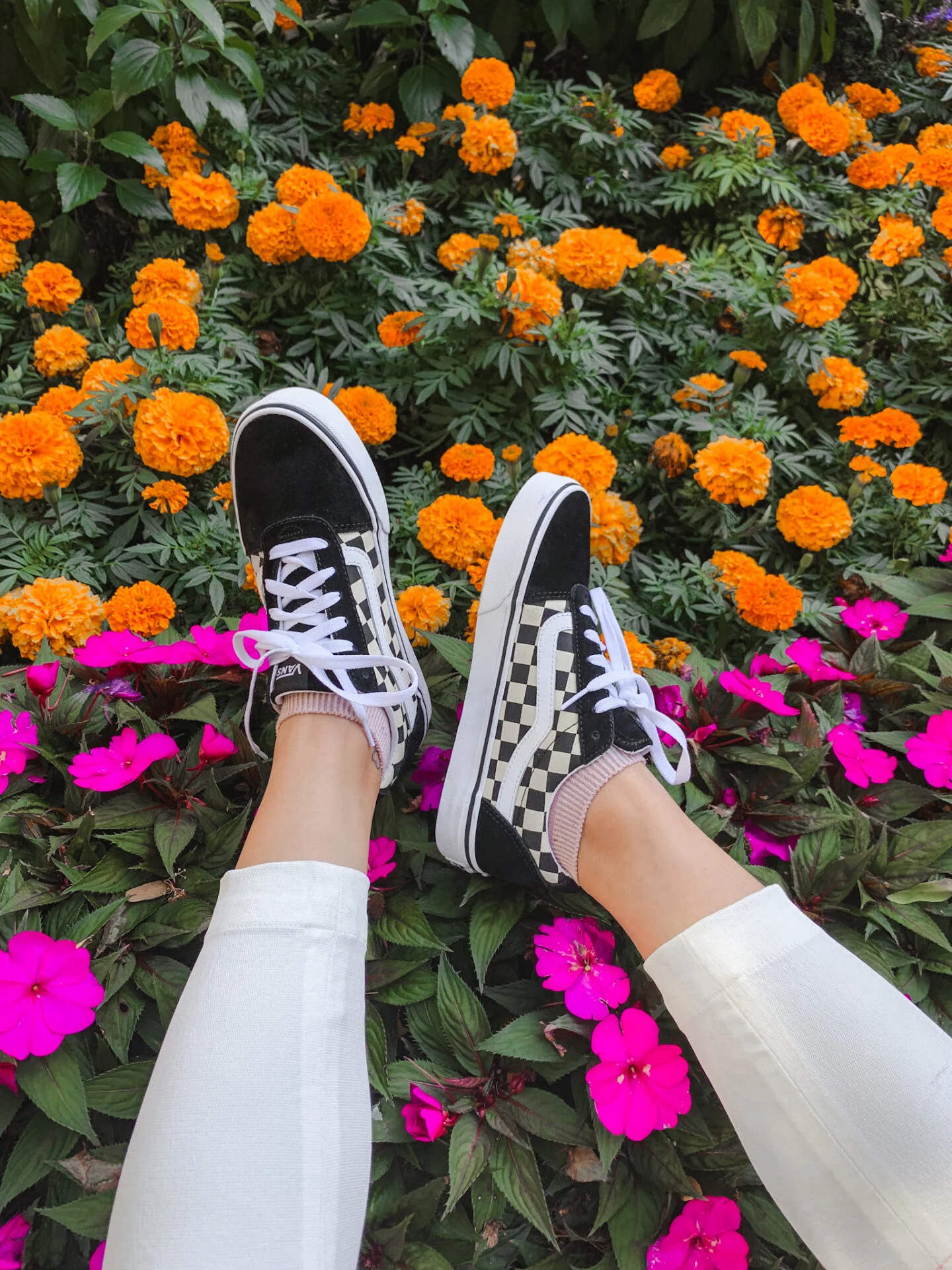 Vans Old Skool Black Sneakers with white pants over fall flowers